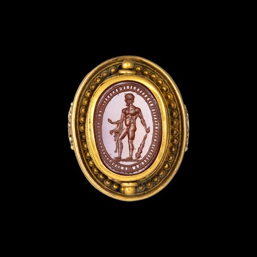 An  Etruscan Revival gold ring set with a swivel carnelian  scarab. Hercules.